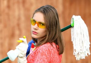 Woman with mop and cleaning product to clear pipes.